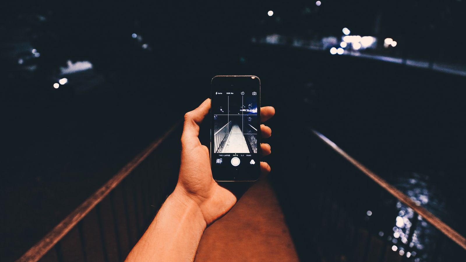 Close-up of a hand holding a glowing smartphone in low light