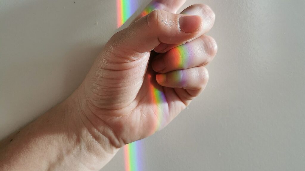 Soft rainbow prism light spread across a wall, symbolizing hope and resilience