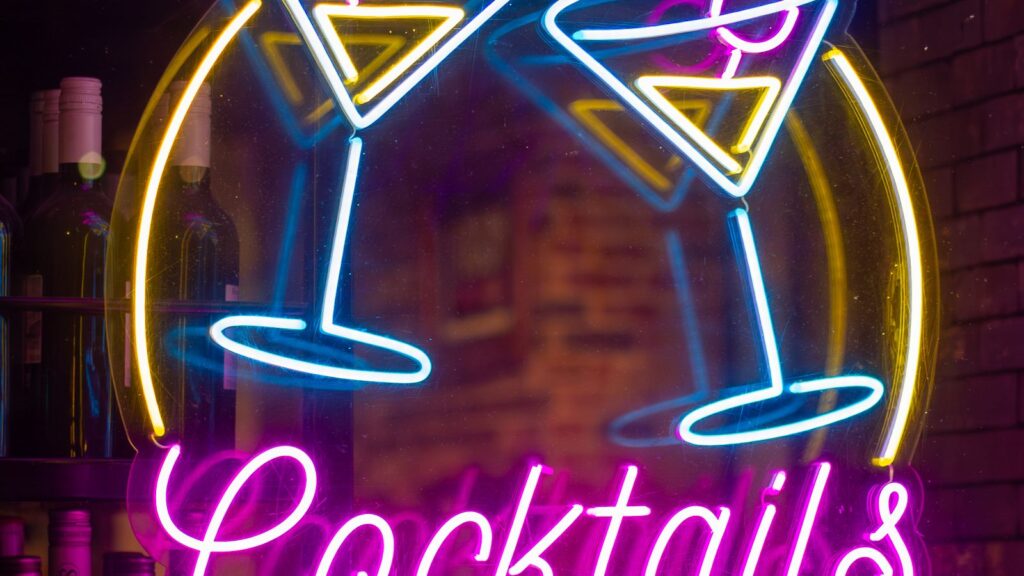 Colorful cocktails arranged on a glowing neon-lit bar top