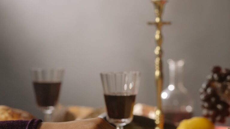 Two hands reaching toward each other across a candlelit table