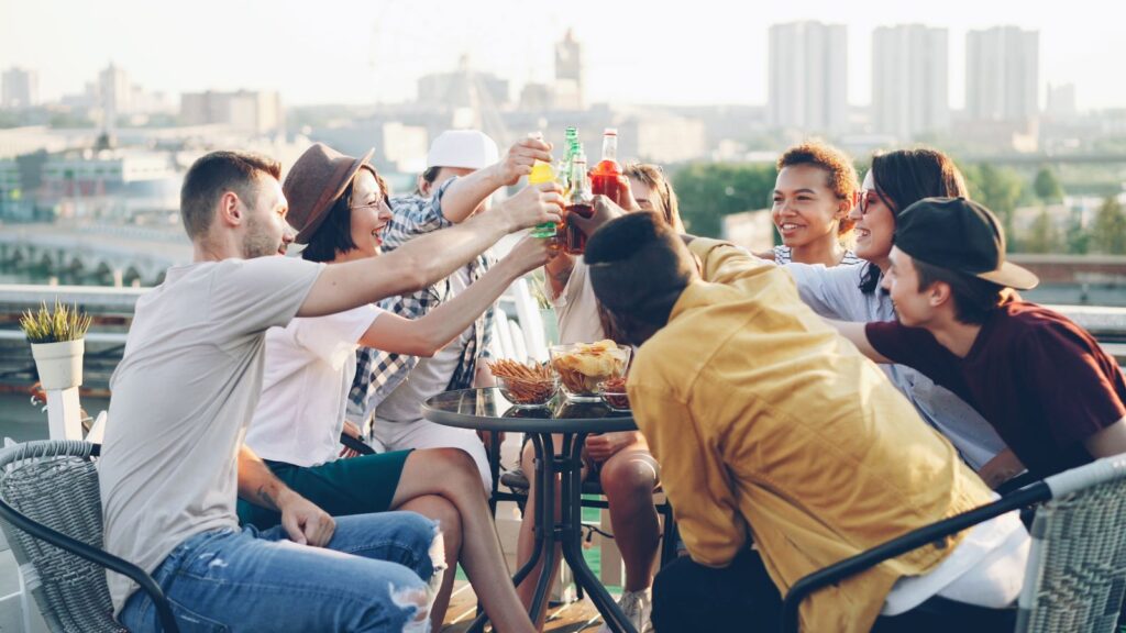 Friends enjoying drinks at a bright daytime rooftop gathering