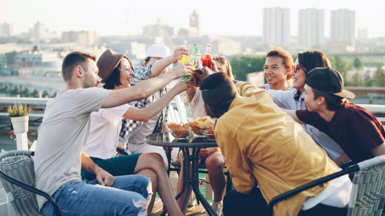 Friends enjoying drinks at a bright daytime rooftop gathering